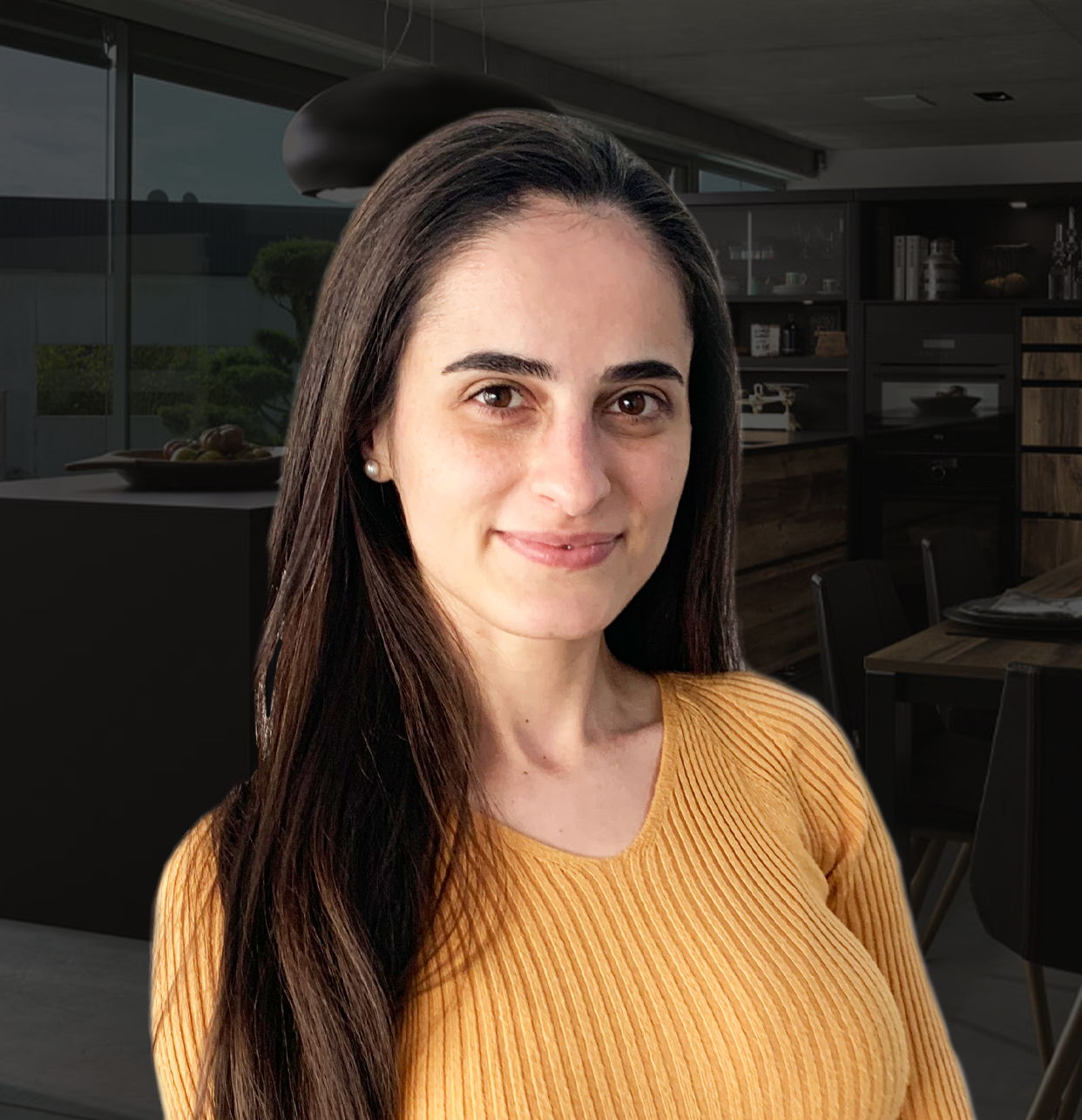 Close-up of a smiling woman with long dark hair standing in front of a modern kitchen. Her professional pose adds a personal touch to the showroom environment.