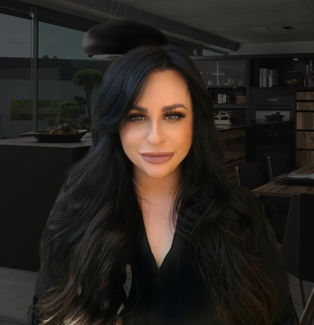 Sophie Cornish colour version – background A confident woman with styled black hair is positioned in front of a high-end kitchen showroom. The portrait adds a modern and polished feel to the setting.