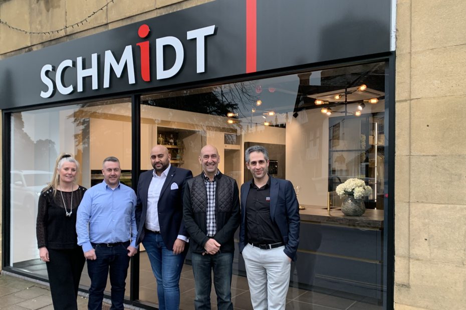 A Schmidt showroom team poses outside the store under modern signage. The clean exterior and professional attire convey a polished and welcoming business image.