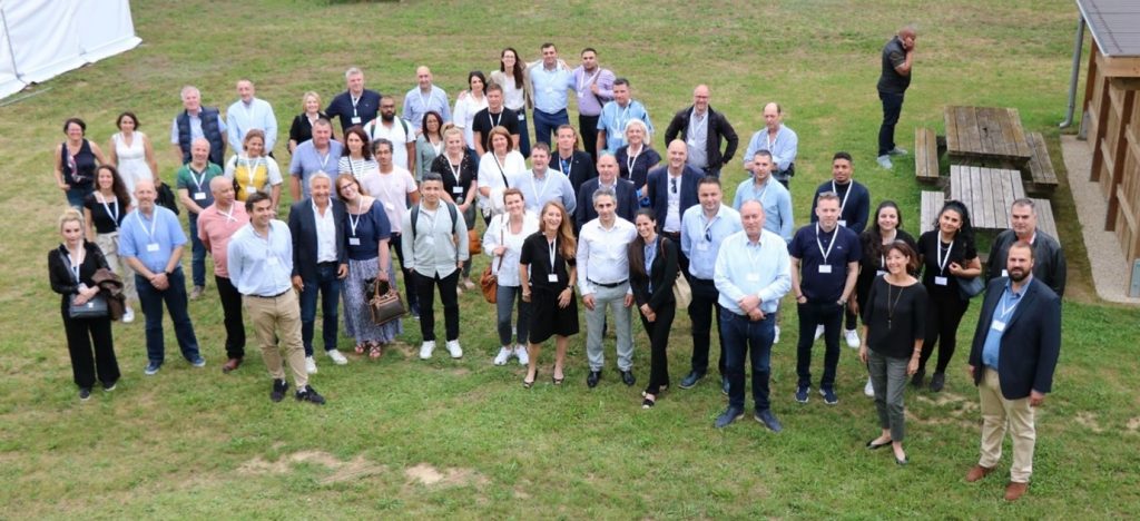 Large group photo of Schmidt franchisees and partners gathered outdoors during an event. Captures team spirit and community within the Schmidt kitchen franchise network.