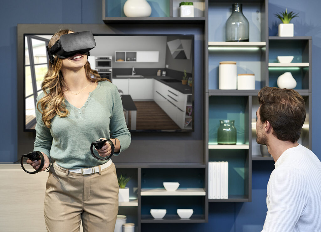 A woman wearing a VR headset explores a digital kitchen layout while seated in a showroom. Demonstrates cutting-edge tech used in interior design visualisation.